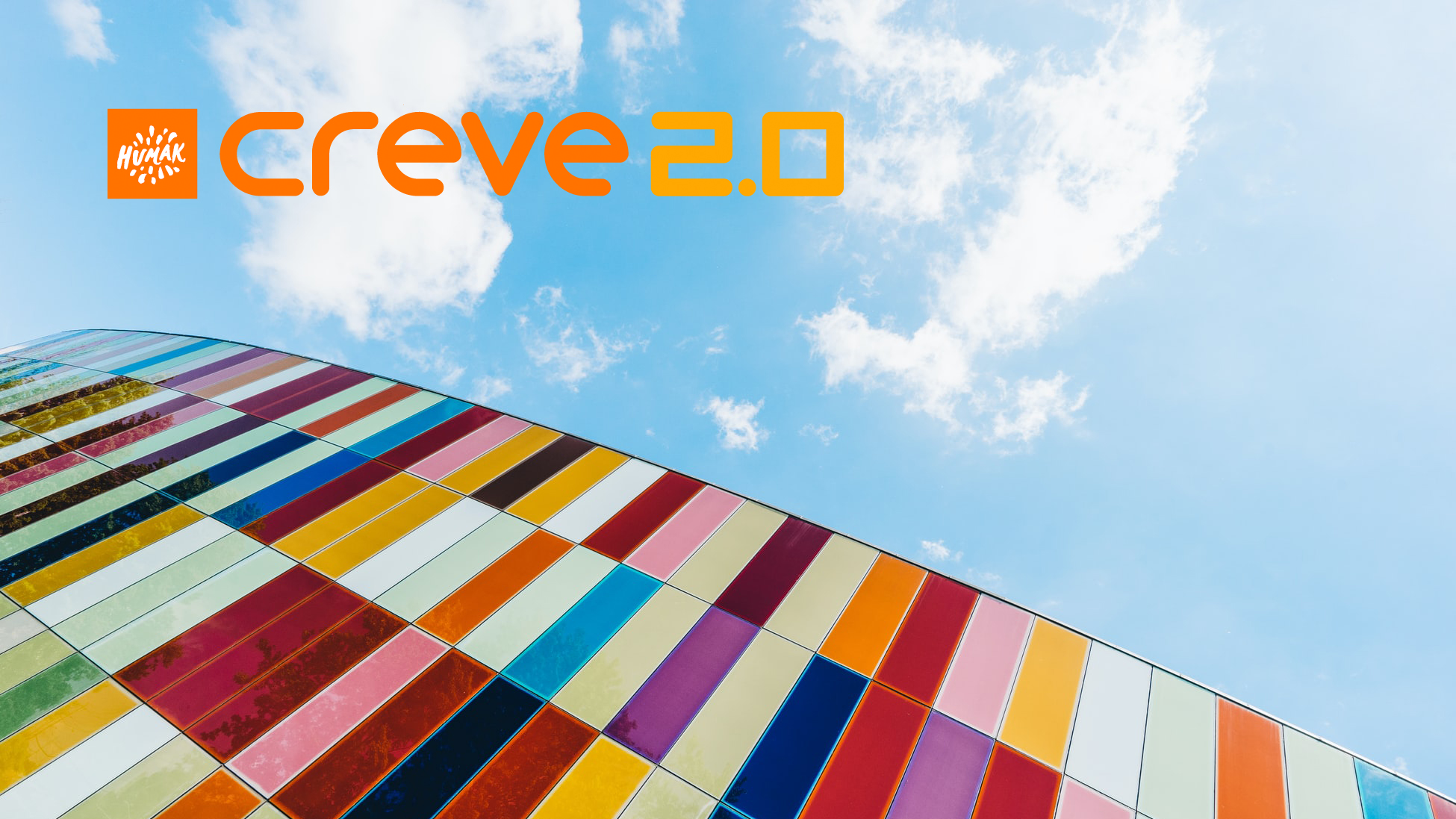 Monenkirjava seinä, jonka yllä taivasta ja Creve 2.0 -hankkeen logo.